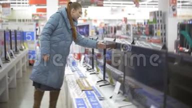 女人在<strong>电子超市</strong>选择厨房电器。